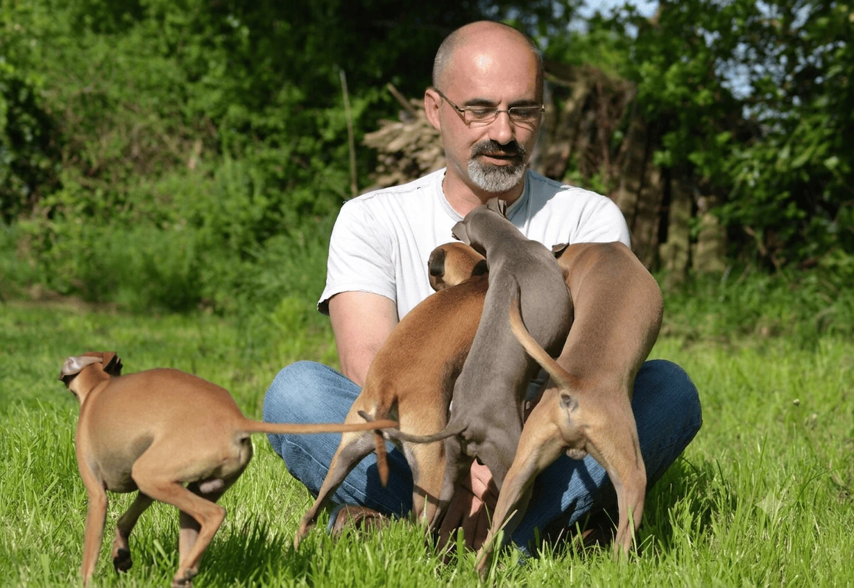 Éleveur avec les chiots dans le jardin de l'élevage